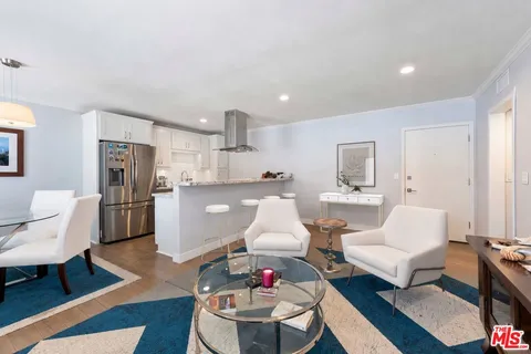a living room with furniture and kitchen view