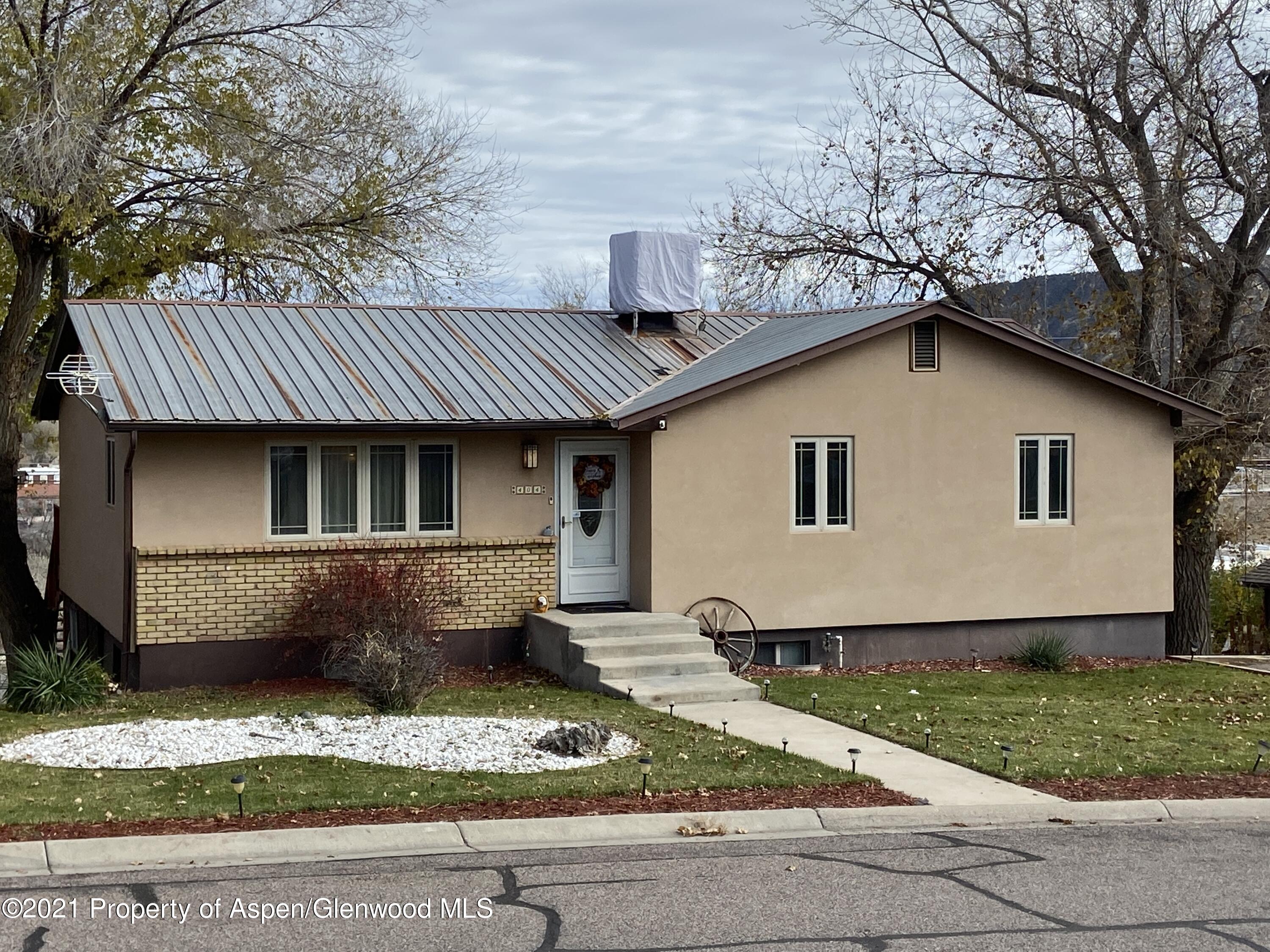 404 Hutton Avenue Rifle, CO 81650 - Photo 1 of 27 a front view of a house with a garden