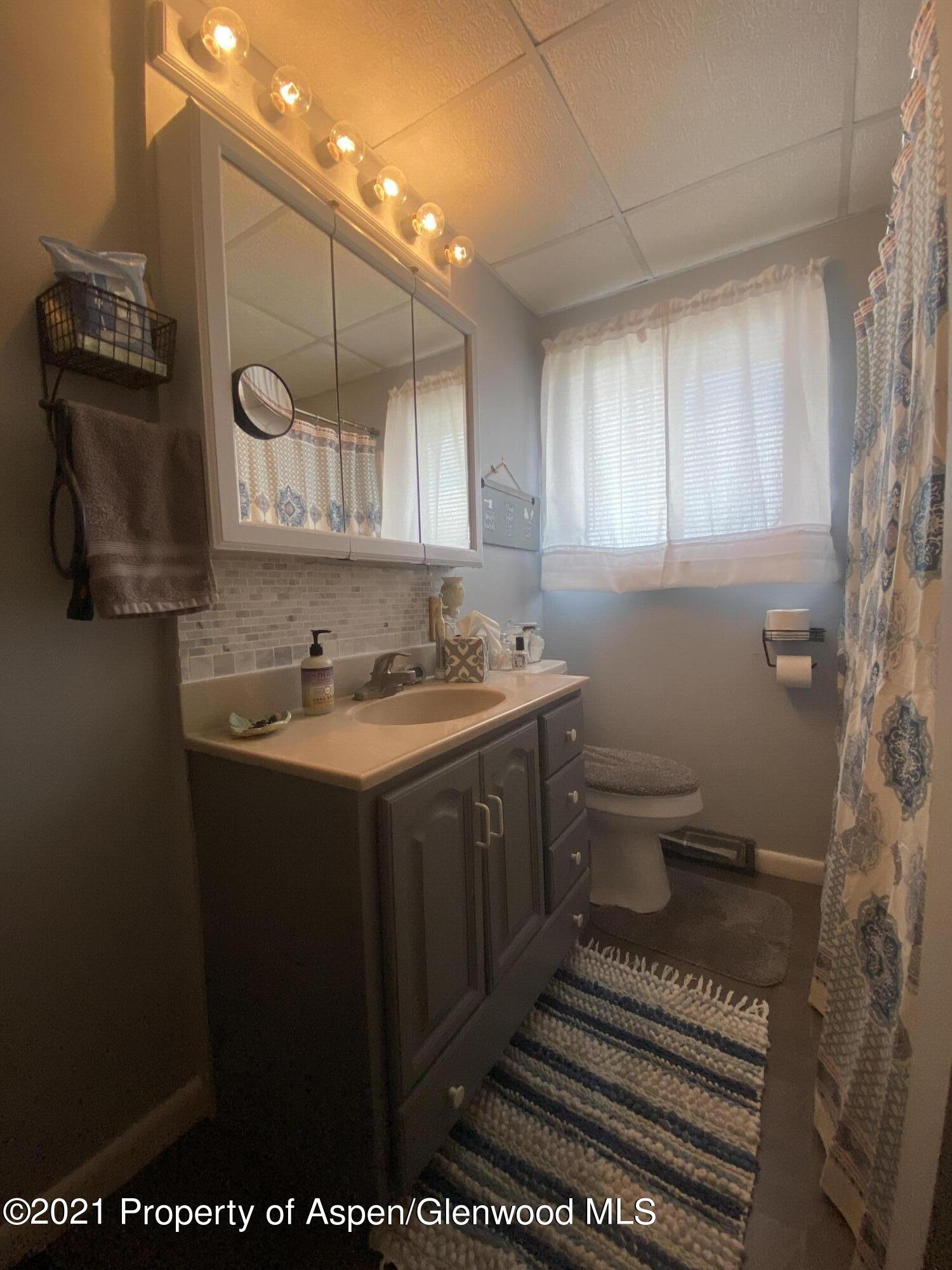 404 Hutton Avenue Rifle, CO 81650 - Photo 14 of 27 a bathroom with a sink toilet and mirror