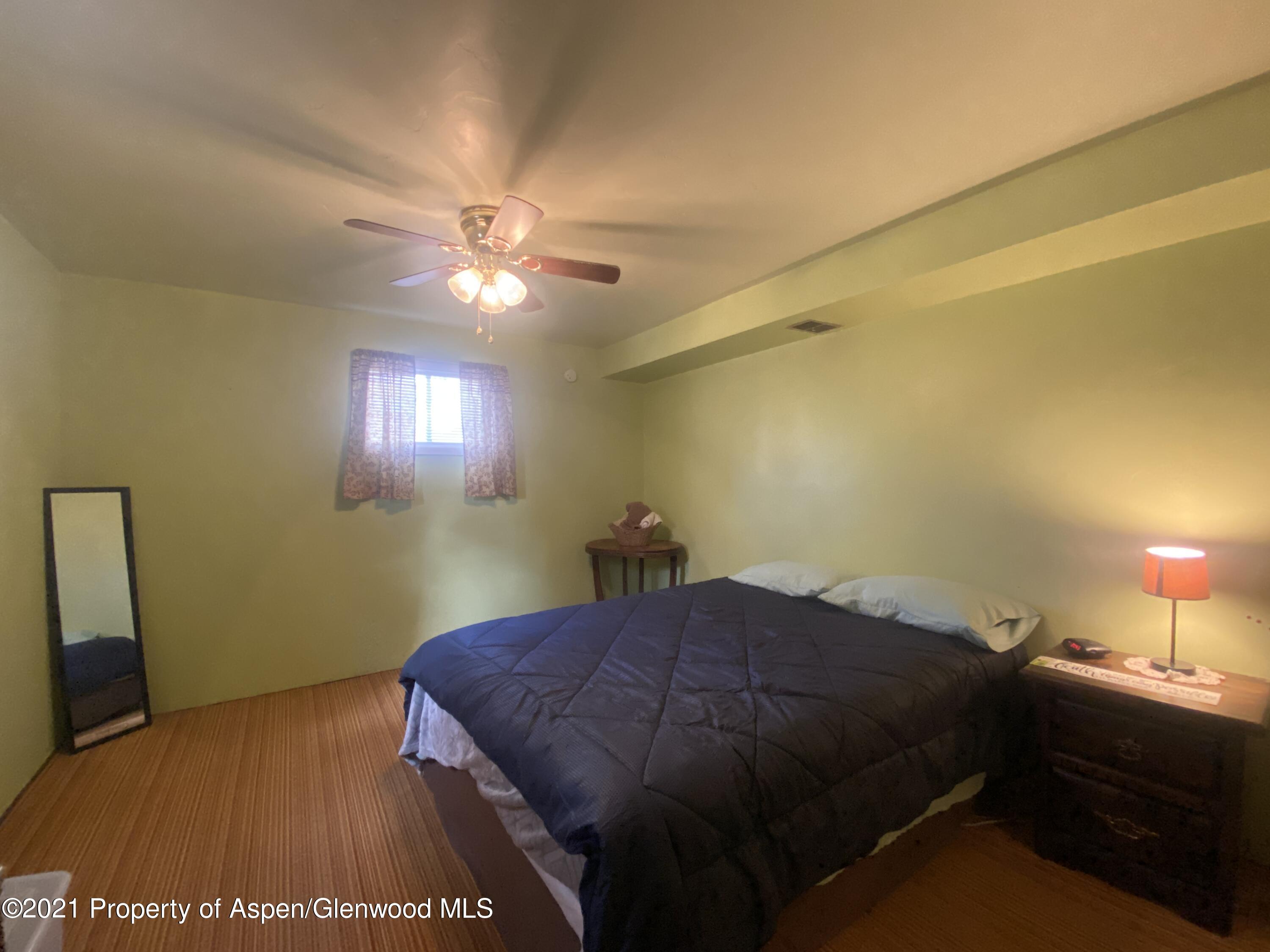 404 Hutton Avenue Rifle, CO 81650 - Photo 21 of 27 a bedroom with a bed and a chandelier