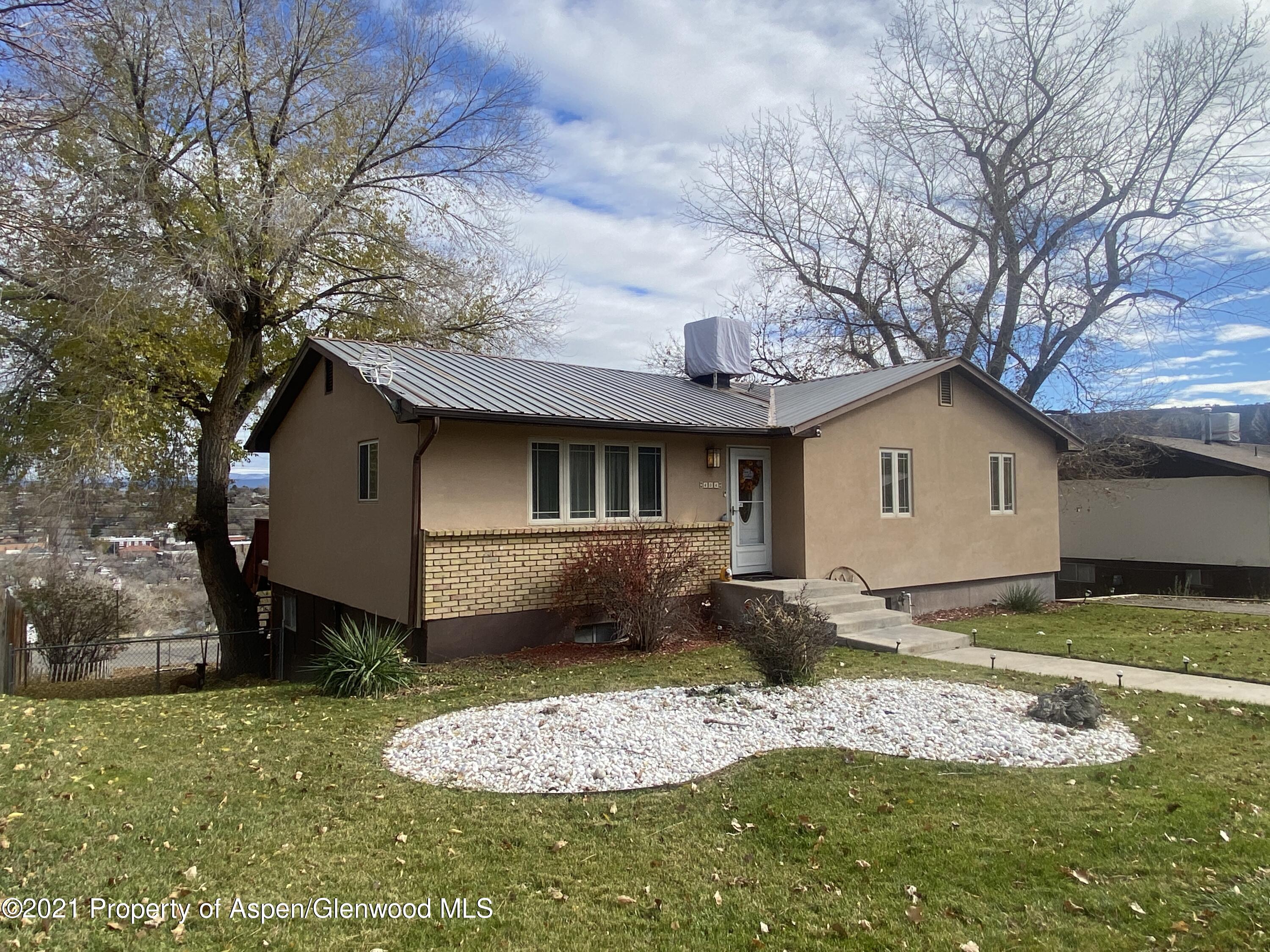 404 Hutton Avenue Rifle, CO 81650 - Photo 3 of 27 a front view of a house with a yard and garage