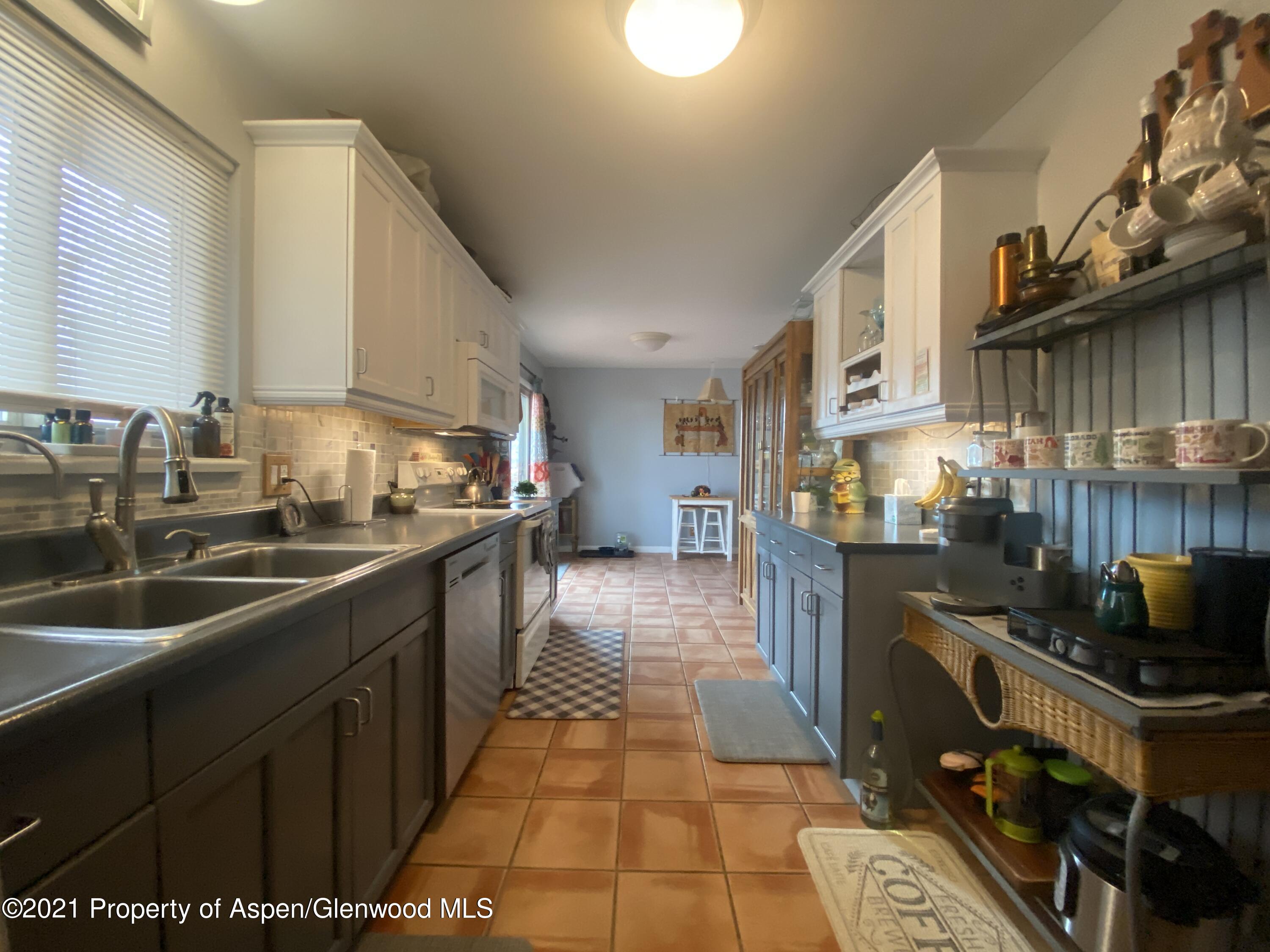 404 Hutton Avenue Rifle, CO 81650 - Photo 10 of 27 a kitchen with stainless steel appliances granite countertop a sink stove and cabinets