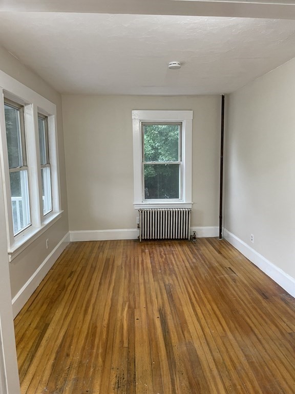 28 Carpenter Road Dudley, MA 01571 - Photo 5 of 6 a view of an empty room with wooden floor and a window