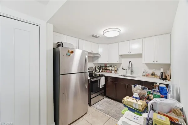 a white refrigerator freezer sitting in a kitchen with stainless steel appliances granite countertop a refrigerator and a sink