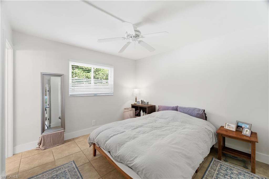 975 9th Avenue South, Unit 2 Naples, FL 34102 - Photo 10 of 18 a bedroom with a bed and a chandelier