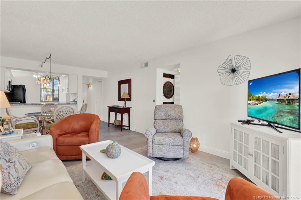 1950 Southwest Palm City Road, Unit 9102 Stuart, FL 34994 - Photo 18 of 51 a living room with furniture and a flat screen tv
