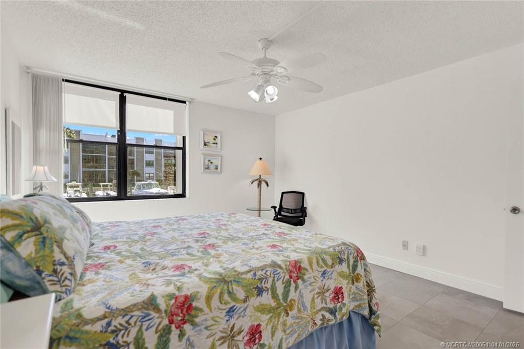1950 Southwest Palm City Road, Unit 9102 Stuart, FL 34994 - Photo 25 of 51 a bedroom with a bed and a large window