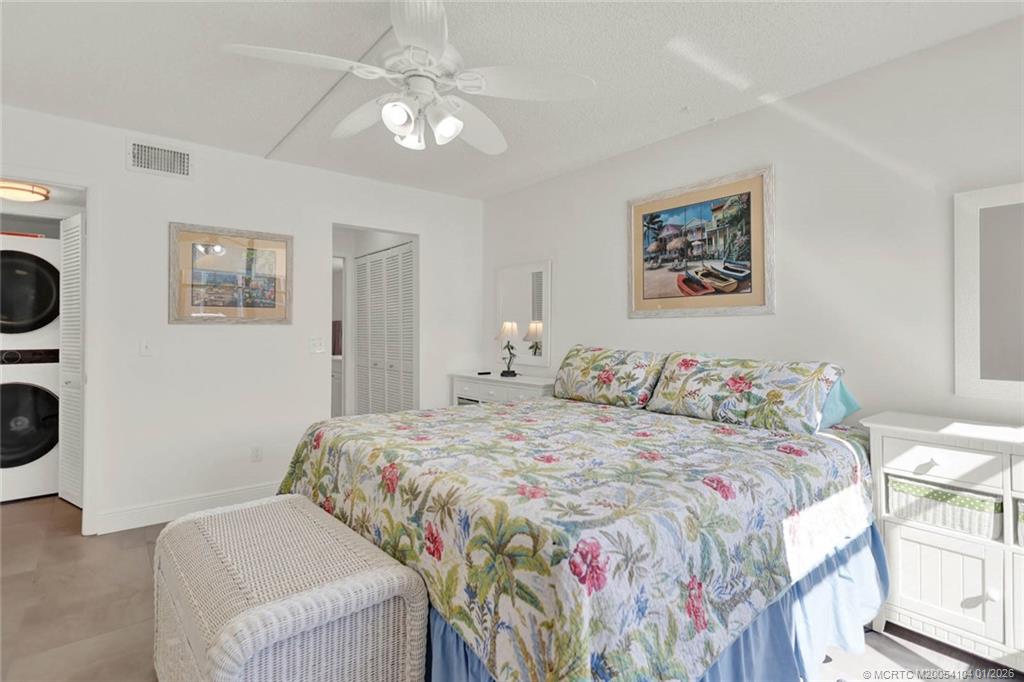 1950 Southwest Palm City Road, Unit 9102 Stuart, FL 34994 - Photo 26 of 51 a bedroom with a bed and a chandelier