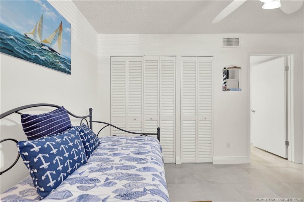 1950 Southwest Palm City Road, Unit 9102 Stuart, FL 34994 - Photo 29 of 51 a bedroom with a bed and a painting on the wall