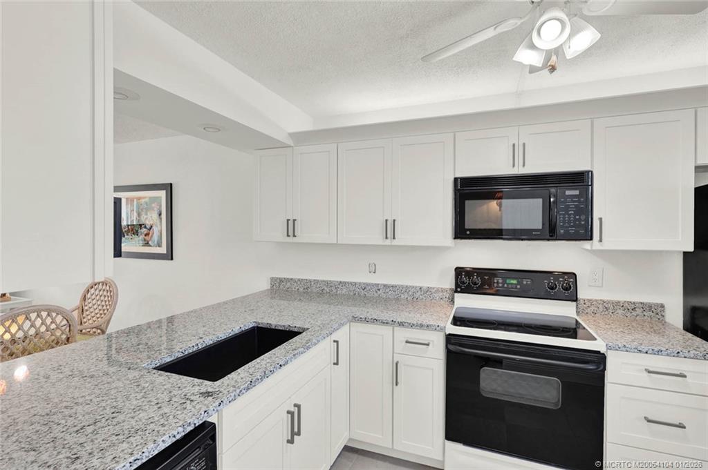 1950 Southwest Palm City Road, Unit 9102 Stuart, FL 34994 - Photo 8 of 51 a kitchen with granite countertop a stove and a sink