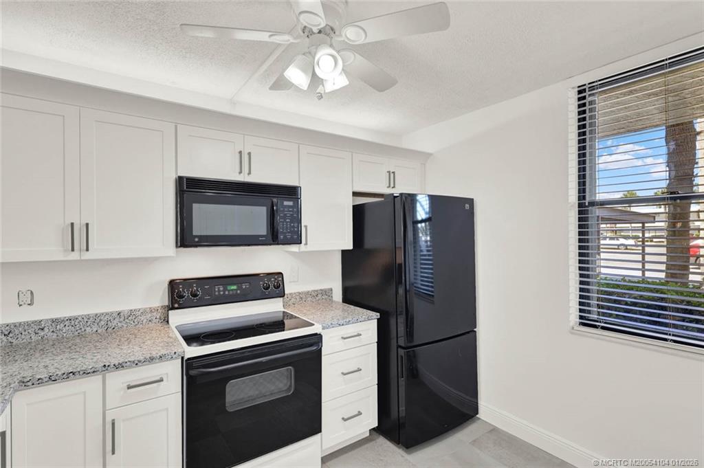 1950 Southwest Palm City Road, Unit 9102 Stuart, FL 34994 - Photo 9 of 51 a kitchen with stainless steel appliances granite countertop a refrigerator stove and microwave