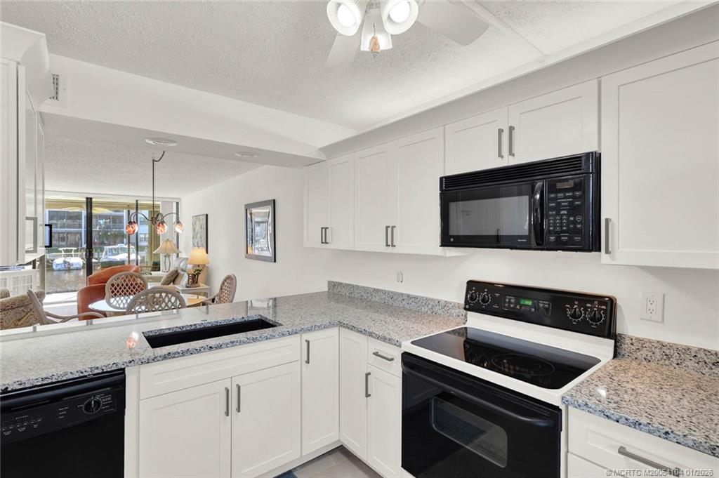 1950 Southwest Palm City Road, Unit 9102 Stuart, FL 34994 - Photo 10 of 51 a kitchen with a sink stove and microwave