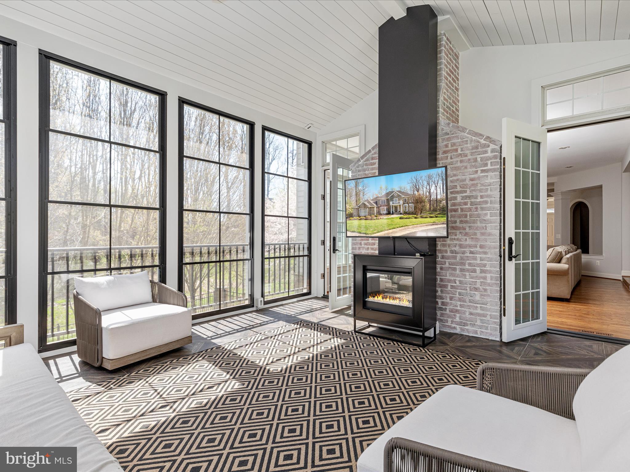 10554 Fox Forest Drive Great Falls, VA 22066 - Photo 20 of 77 a living room with furniture a fireplace and a floor to ceiling window