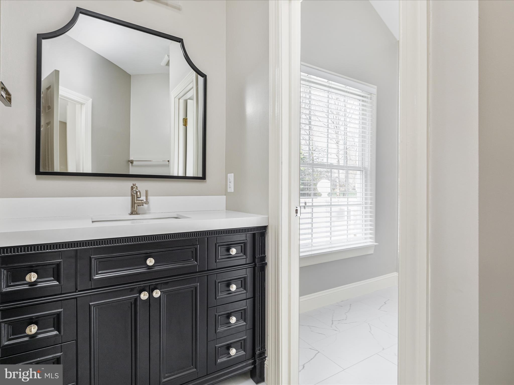 10554 Fox Forest Drive Great Falls, VA 22066 - Photo 38 of 77 a bathroom with a sink a mirror and a window
