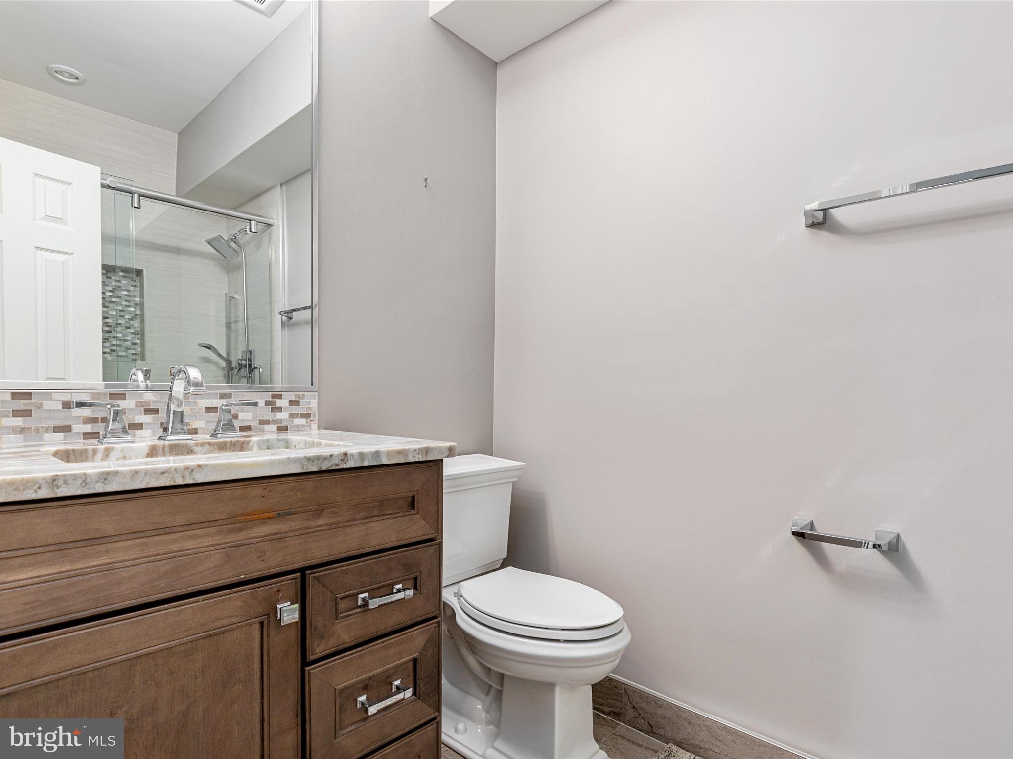 10554 Fox Forest Drive Great Falls, VA 22066 - Photo 50 of 77 a bathroom with a granite countertop toilet sink and mirror