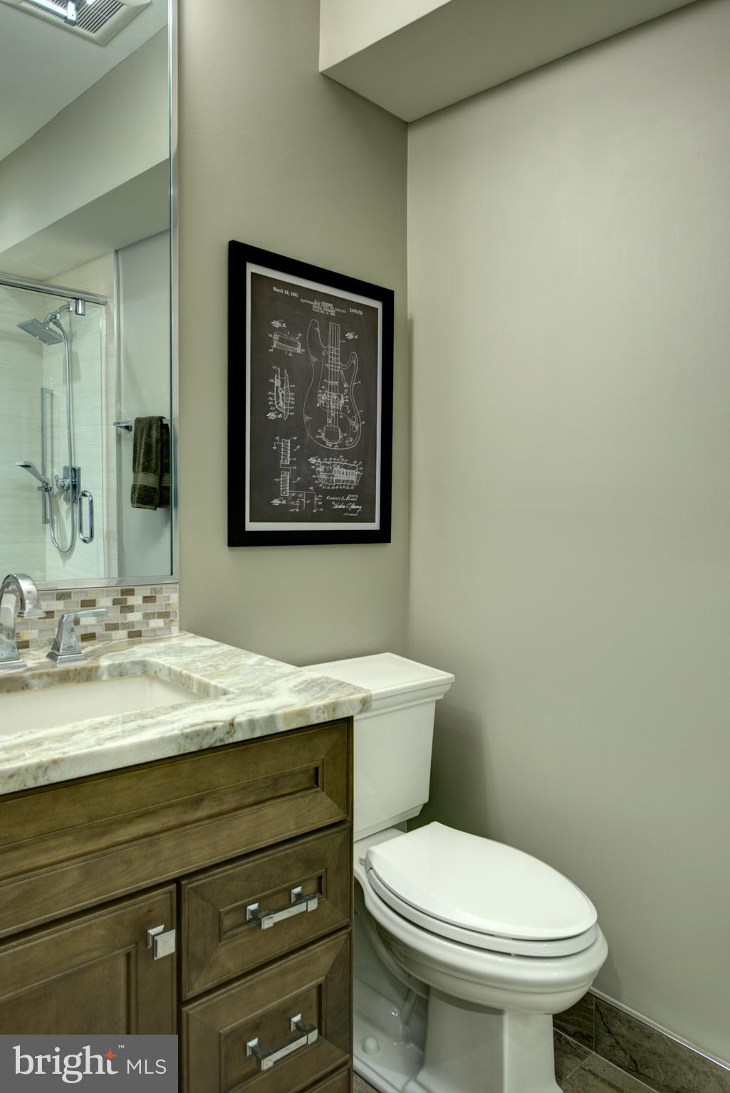 10554 Fox Forest Drive Great Falls, VA 22066 - Photo 51 of 77 a bathroom with a granite countertop toilet sink and mirror