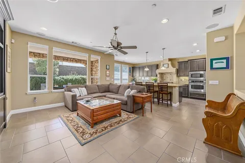 a living room with furniture a rug kitchen view and a chandelier