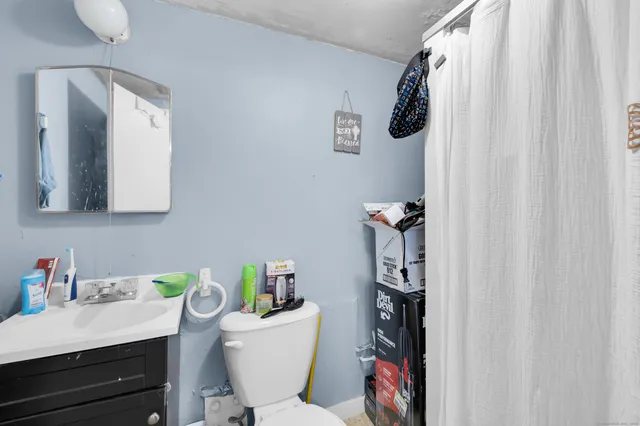 a bathroom with a toilet a sink and mirror