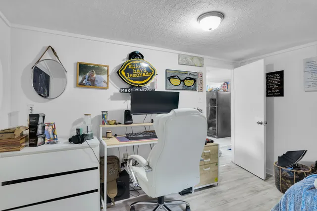 a view of a workspace with furniture and a wooden floor
