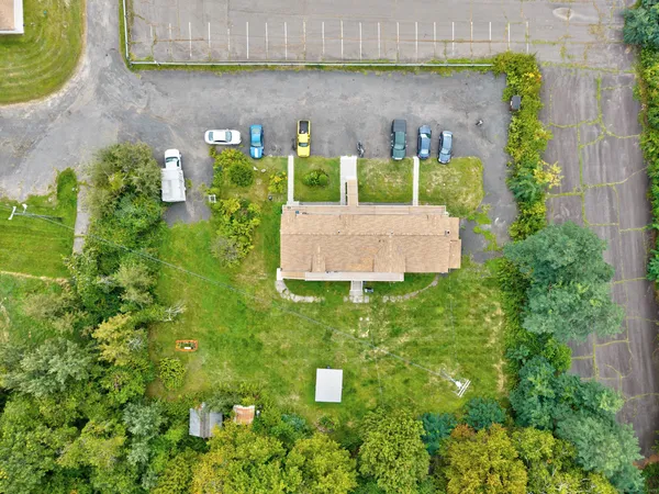 an aerial view of a house with a yard and large tree