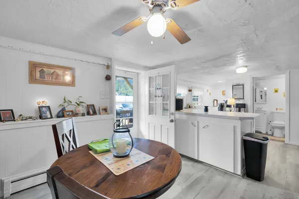 a view of a dining room with furniture a kitchen and chandelier