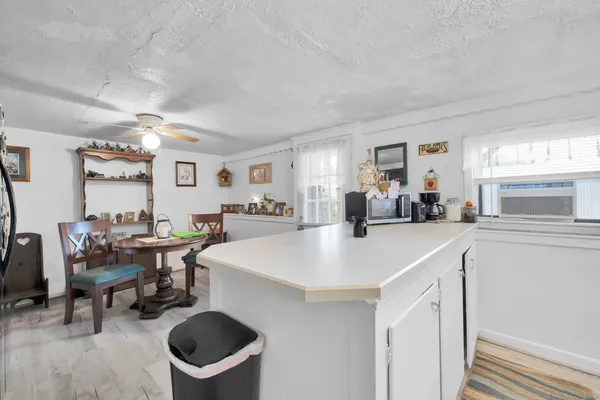 a view of kitchen island with stainless steel appliances refrigerator stove dining table and chairs