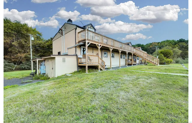 a view of a house with a yard and sitting area