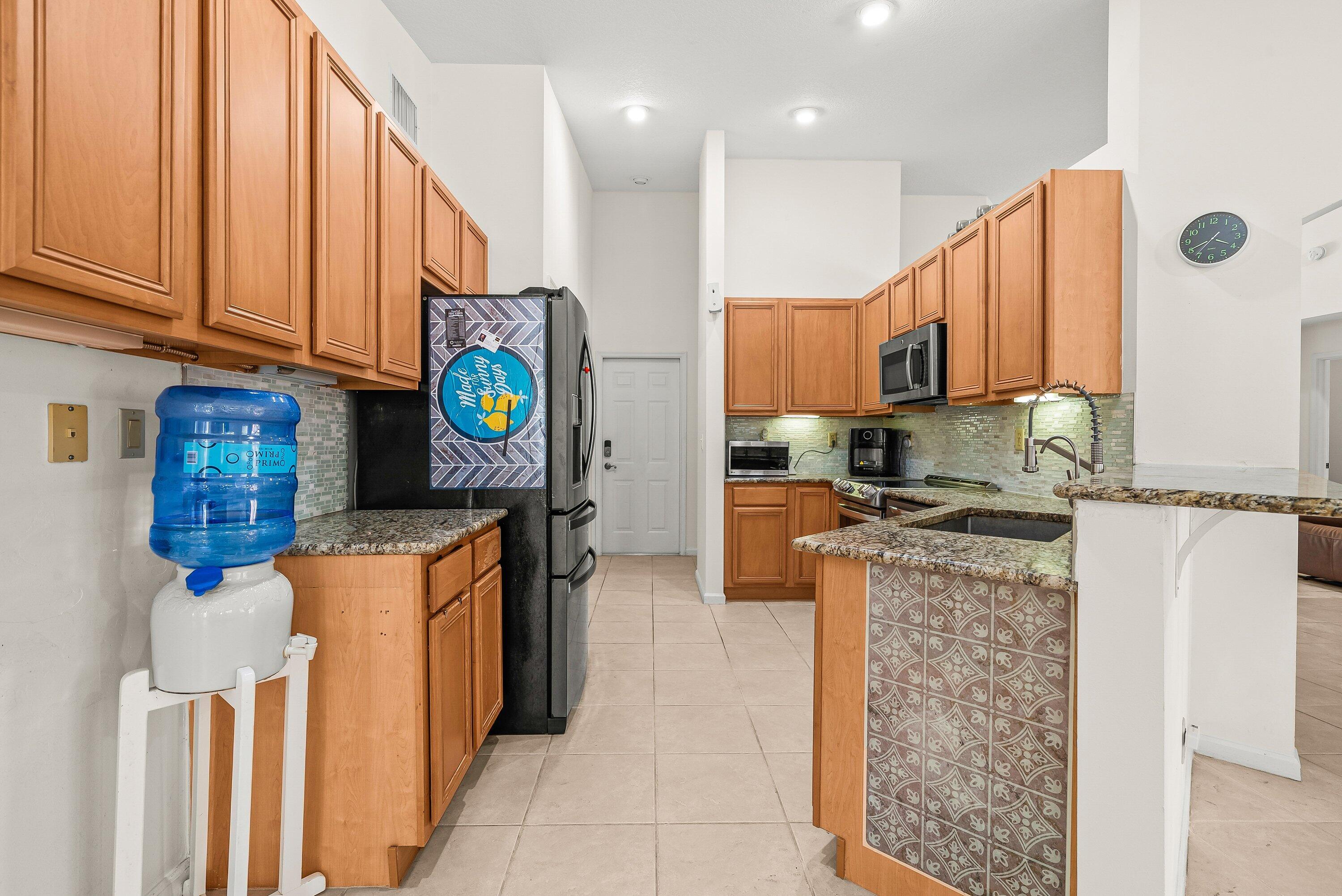 18098 93rd Road North The Acreage, FL 33470 - Photo 14 of 60 a kitchen with stainless steel appliances granite countertop a refrigerator a stove and a sink