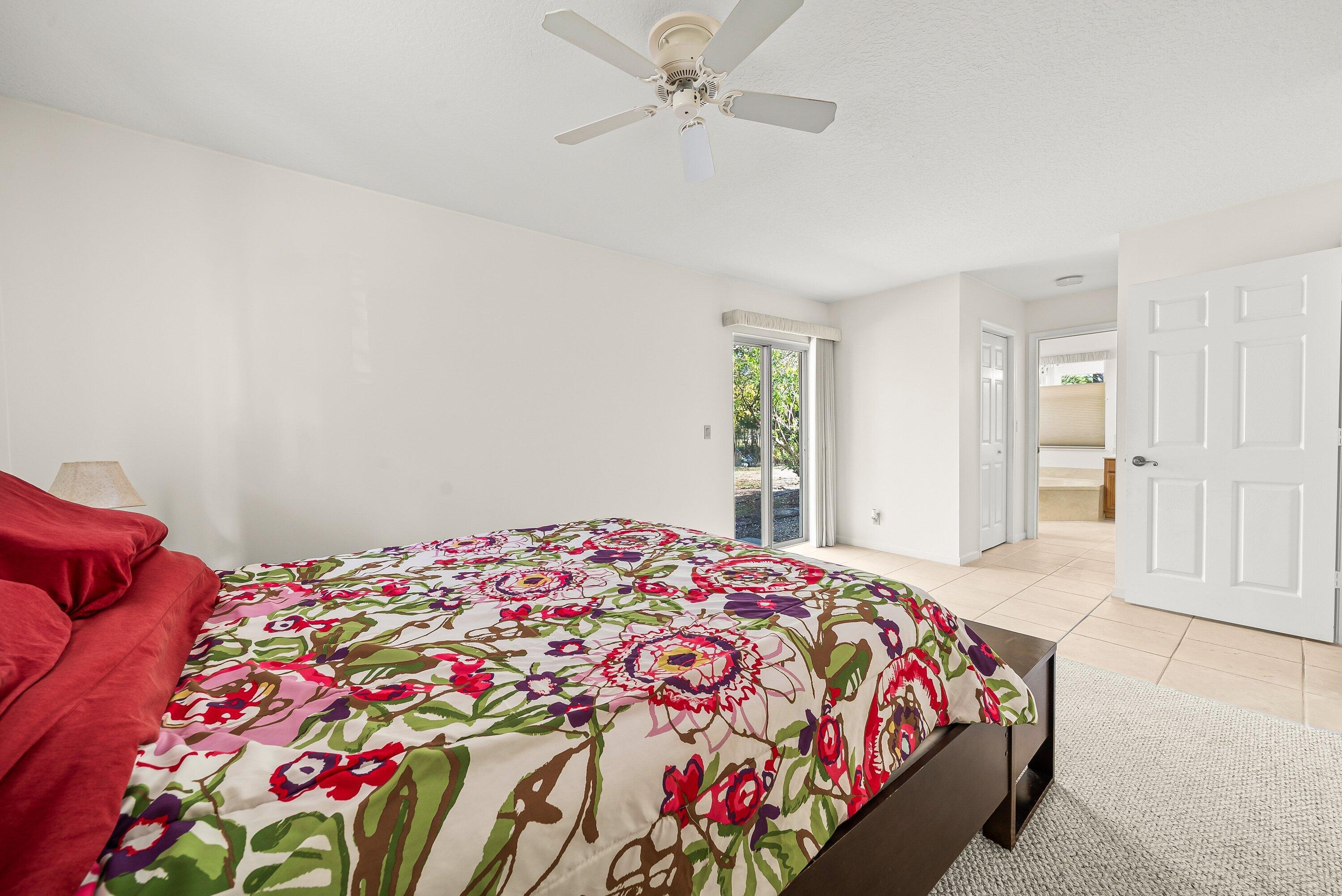 18098 93rd Road North The Acreage, FL 33470 - Photo 23 of 60 a bedroom with a bed and a chandelier