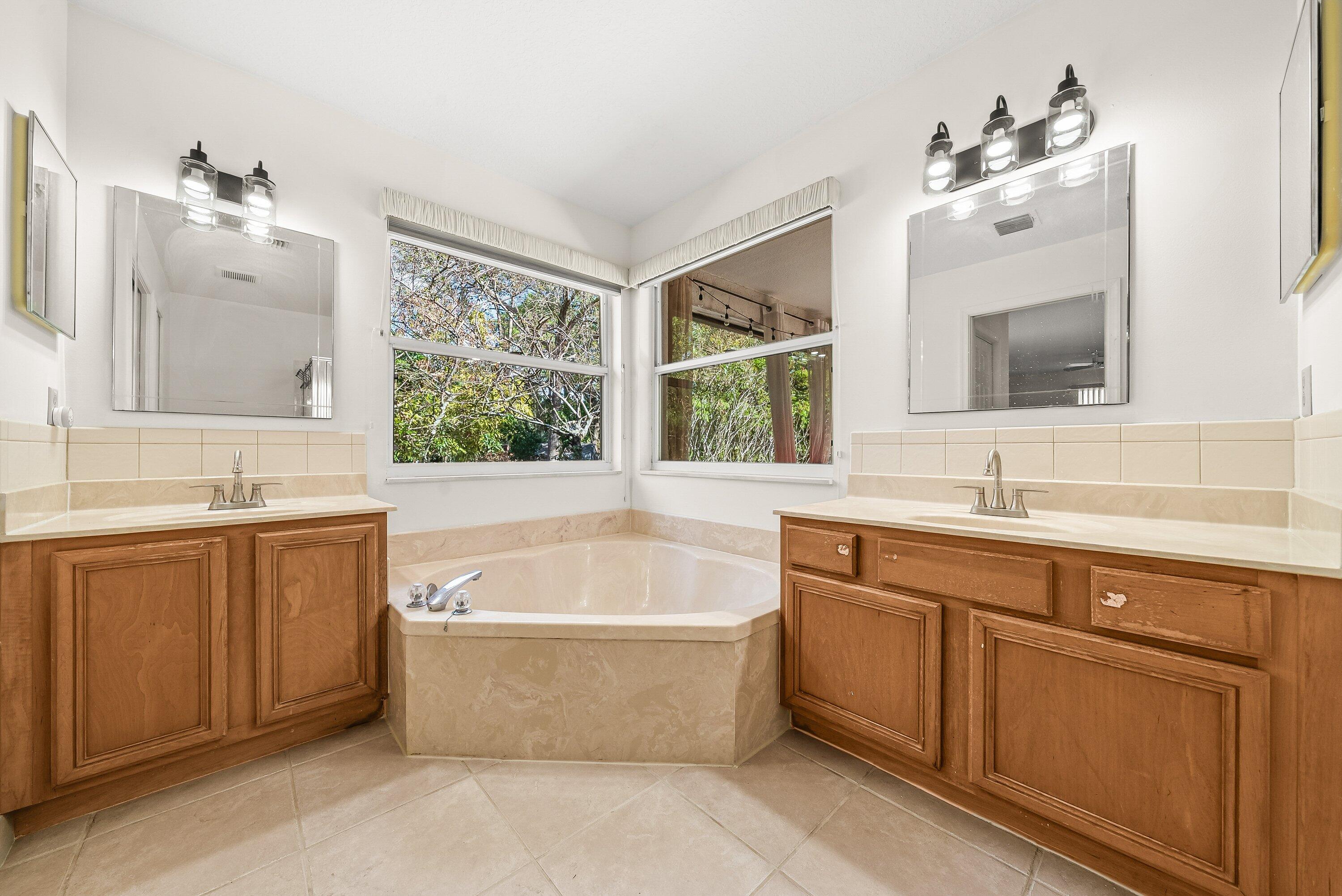 18098 93rd Road North The Acreage, FL 33470 - Photo 25 of 60 a spacious bathroom with a tub double sink and mirror