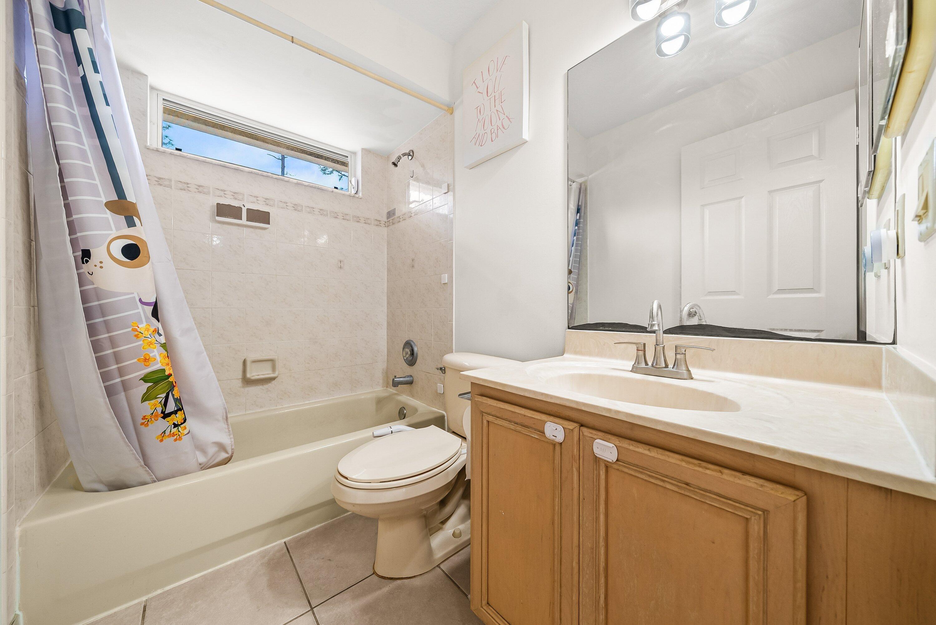 18098 93rd Road North The Acreage, FL 33470 - Photo 29 of 60 a bathroom with a sink a toilet a mirror a vanity and shower