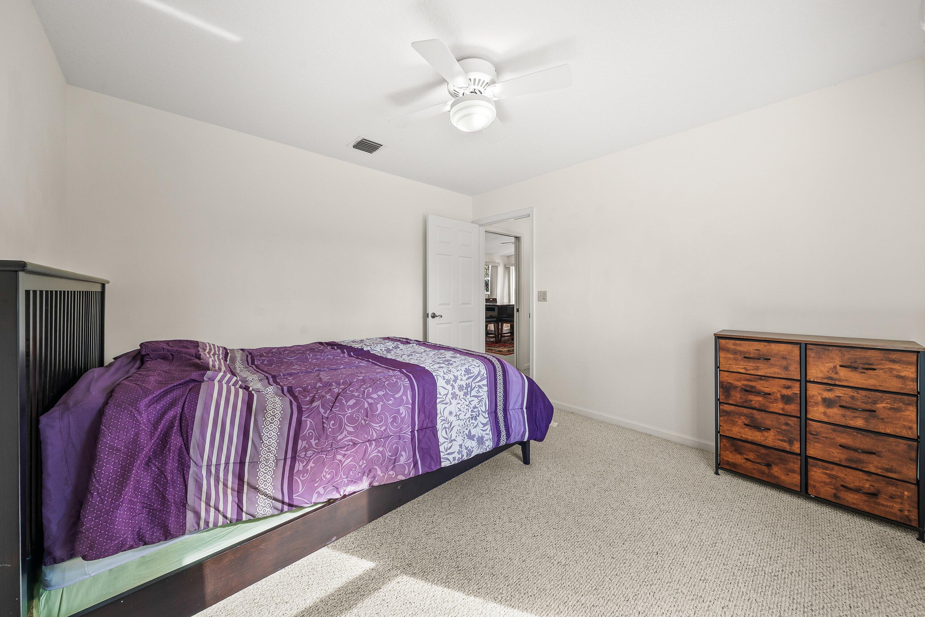 18098 93rd Road North The Acreage, FL 33470 - Photo 31 of 60 a bedroom with a bed and a chandelier fan