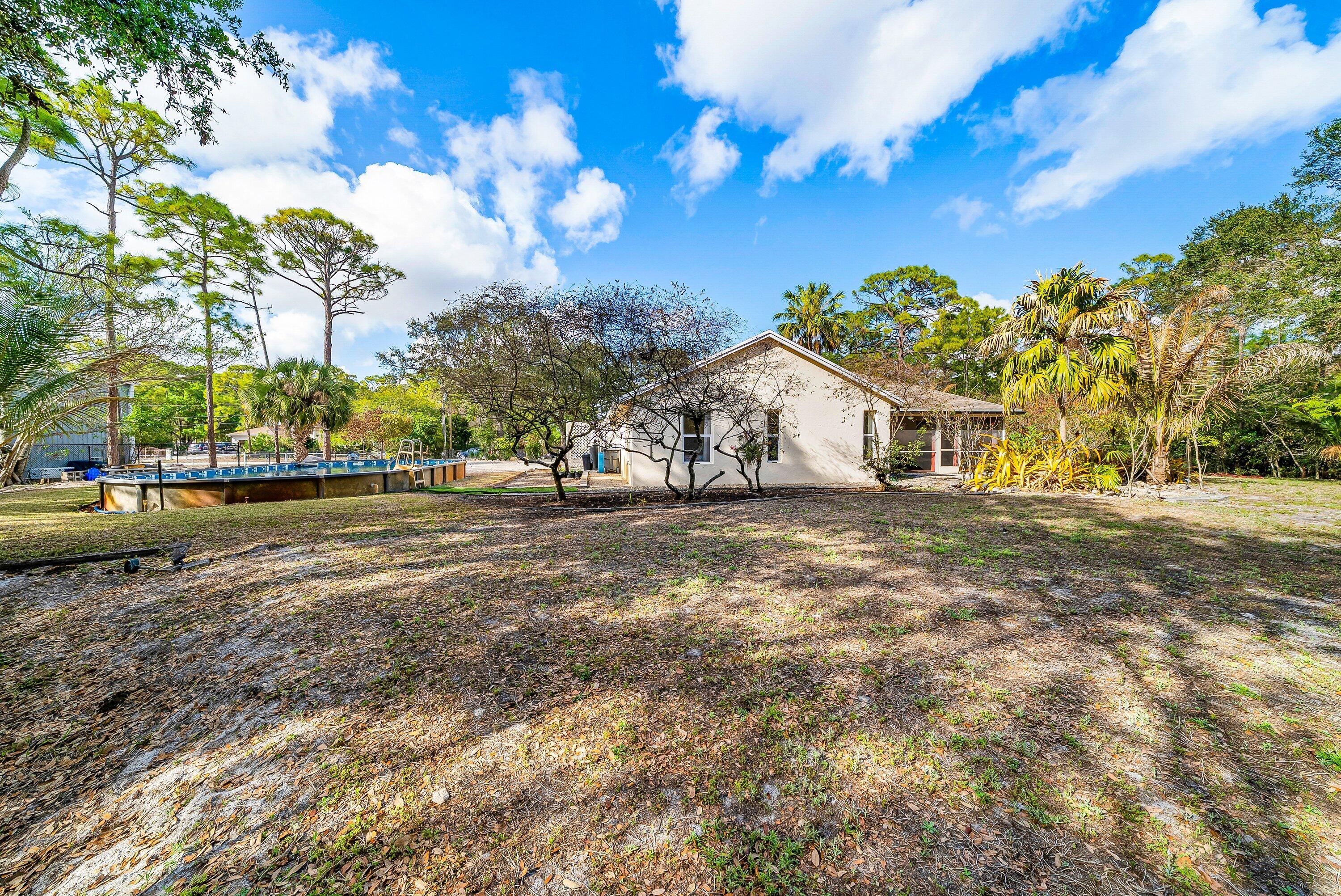 18098 93rd Road North The Acreage, FL 33470 - Photo 43 of 60 a view of a white house with a yard