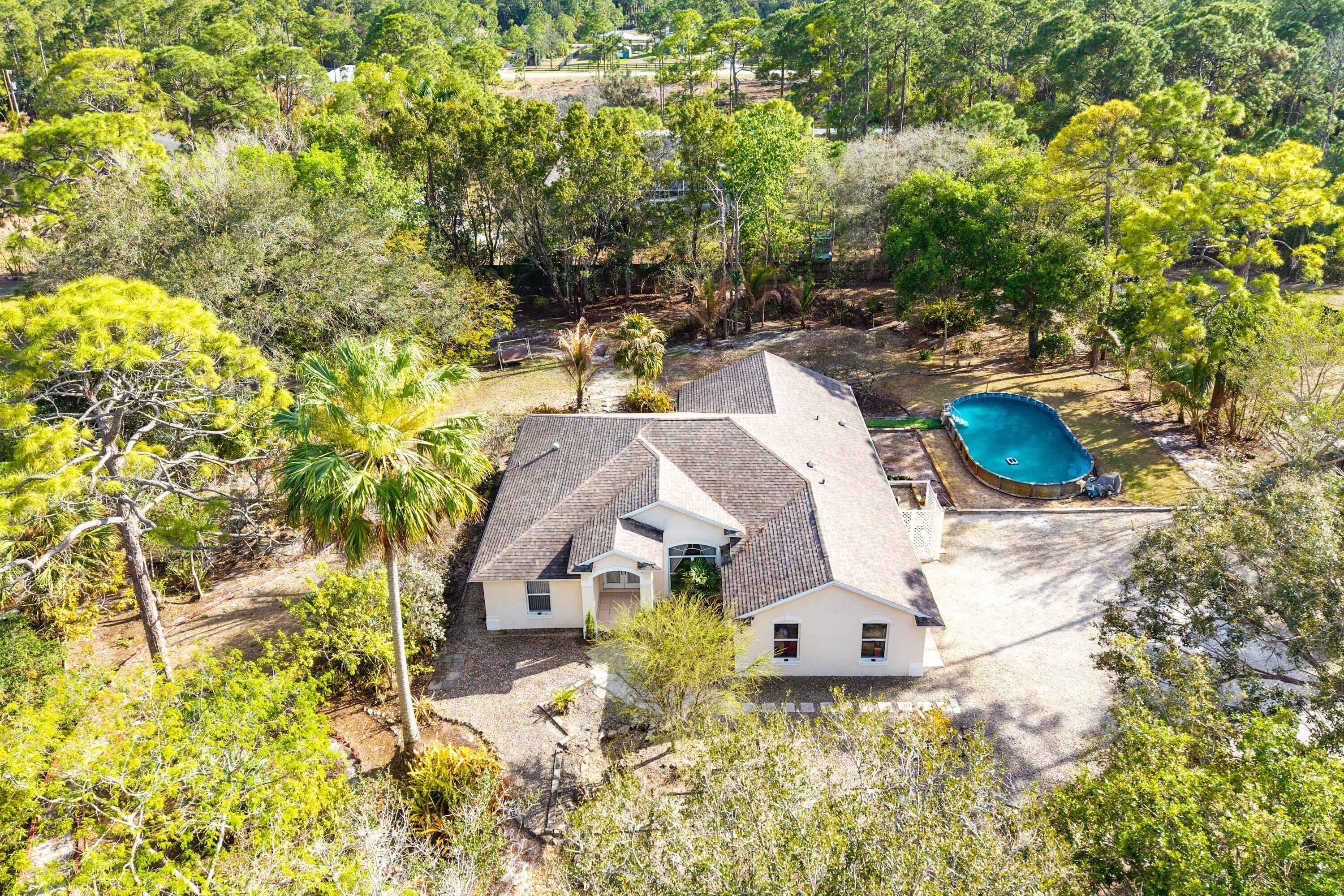 18098 93rd Road North The Acreage, FL 33470 - Photo 49 of 60 an aerial view of a house with swimming pool and large trees