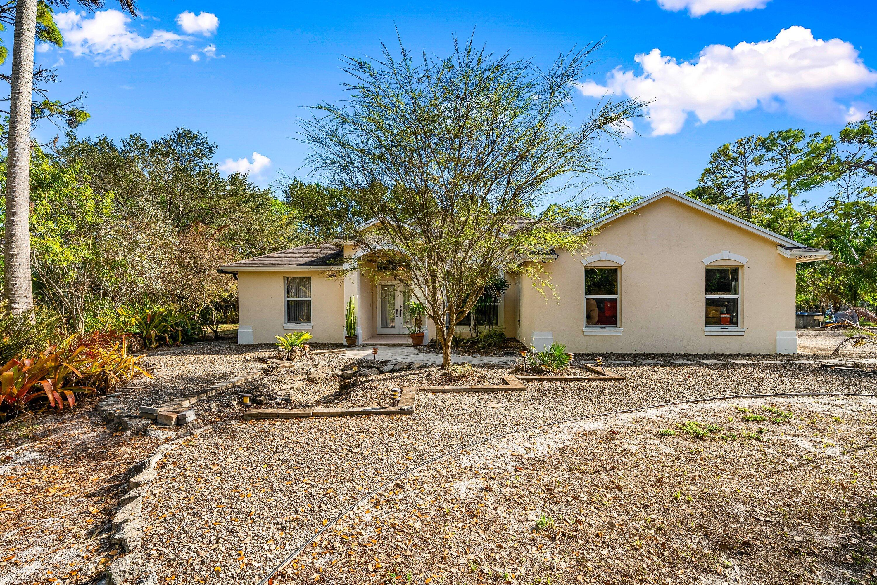 18098 93rd Road North The Acreage, FL 33470 - Photo 5 of 60 a backyard of a house with table and chairs