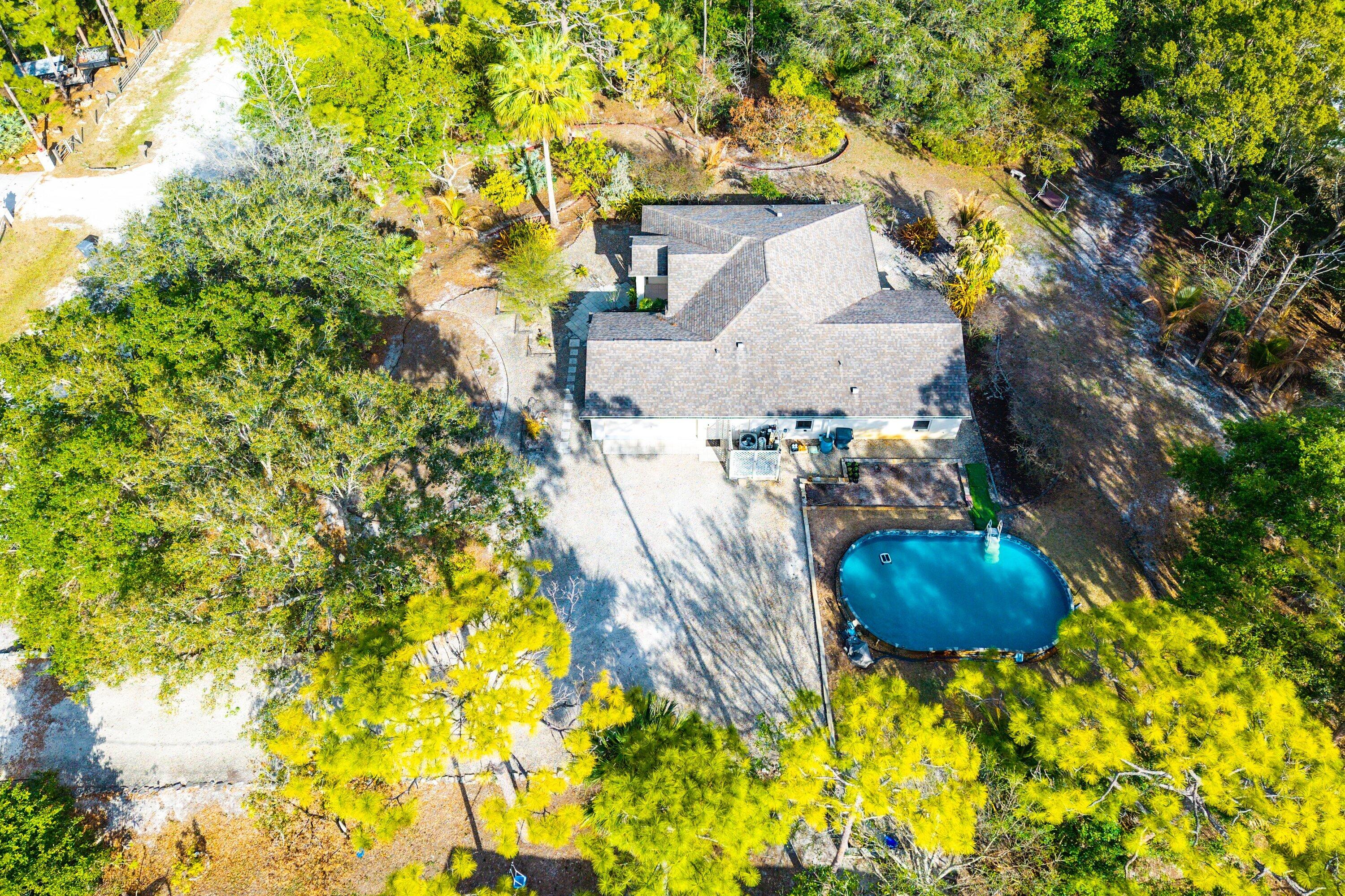 18098 93rd Road North The Acreage, FL 33470 - Photo 51 of 60 a backyard of a house with table and chairs and potted plants