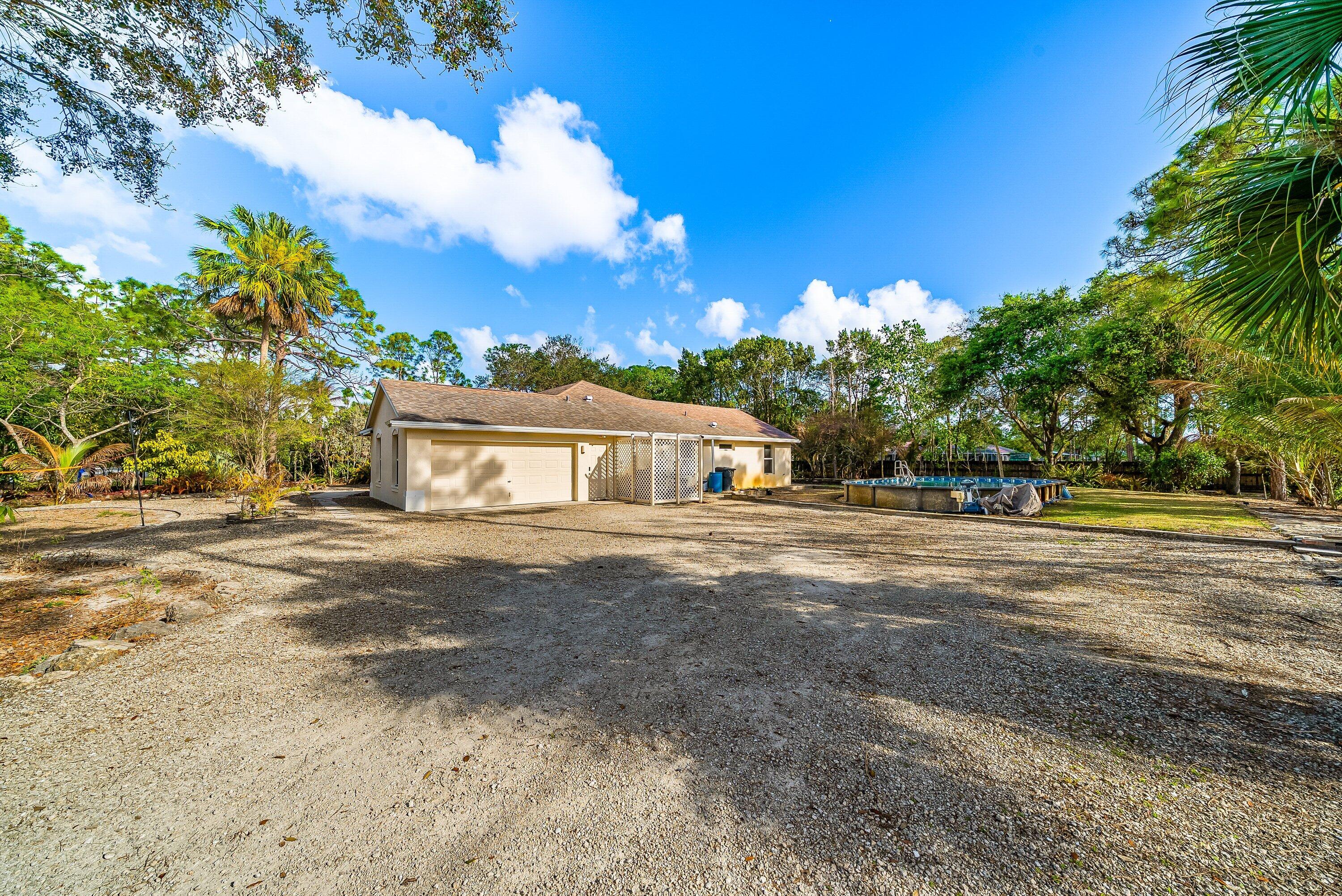 18098 93rd Road North The Acreage, FL 33470 - Photo 8 of 60 a view of a house with a yard and large tree