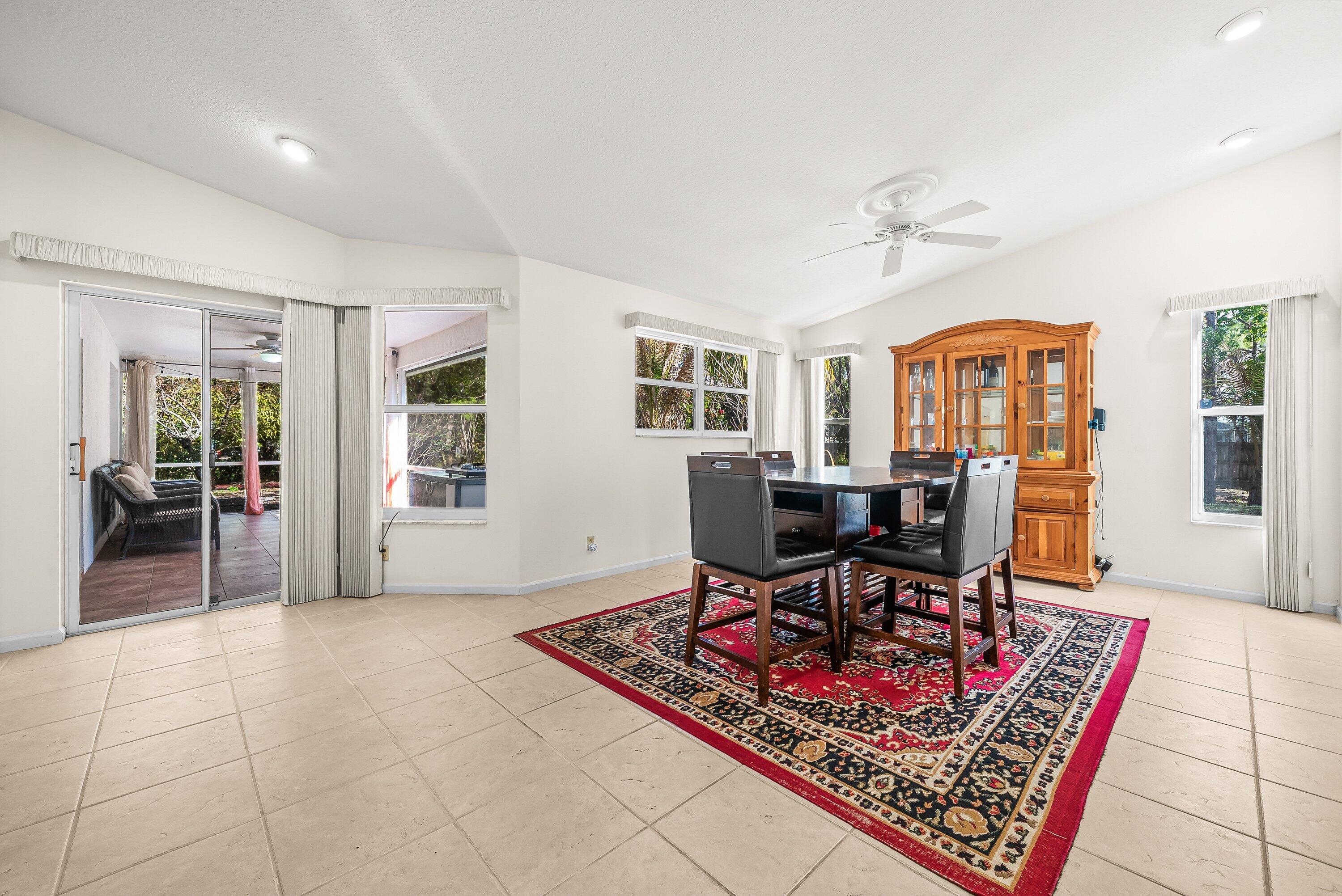 18098 93rd Road North The Acreage, FL 33470 - Photo 9 of 60 a living room with furniture a dining table and large window with wooden floor