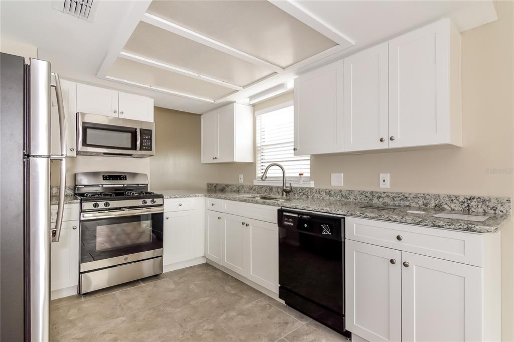 3211 Timberline Road Winter Haven, FL 33880 - Photo 5 of 15 a kitchen with granite countertop a sink stainless steel appliances and white cabinets