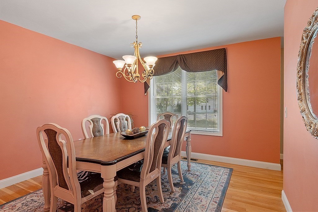 63 Manchester Street Nashua, NH 03064 - Photo 18 of 39 a view of a dining room with furniture a chandelier and wooden floor