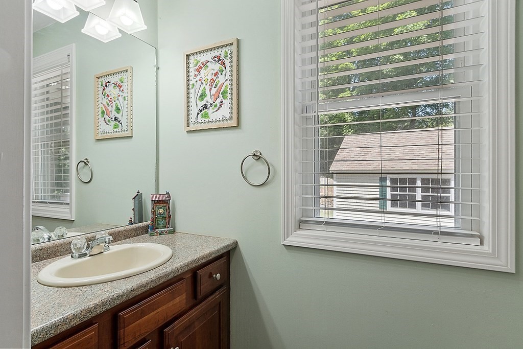 63 Manchester Street Nashua, NH 03064 - Photo 20 of 39 a bathroom with a granite countertop sink a mirror and a window