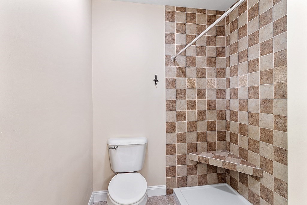 63 Manchester Street Nashua, NH 03064 - Photo 26 of 39 a white toilet sitting next to a shower curtain