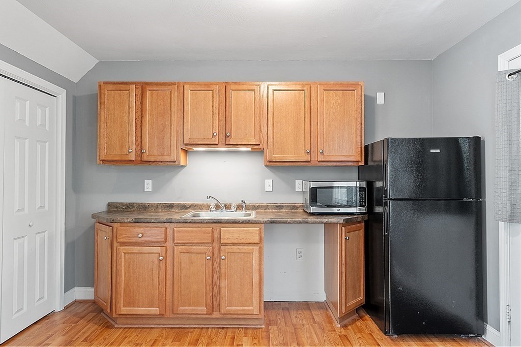 63 Manchester Street Nashua, NH 03064 - Photo 34 of 39 a kitchen with a refrigerator sink and cabinets
