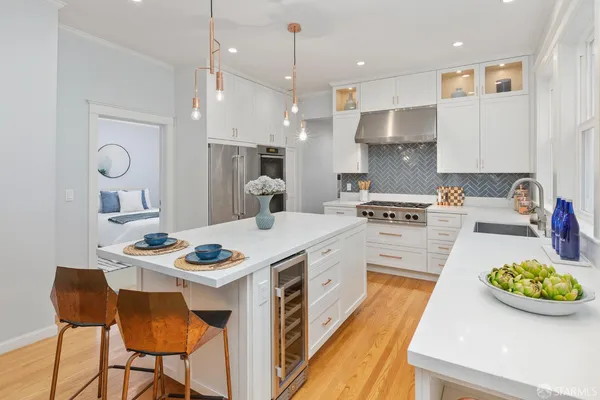 a kitchen that has a lot of cabinets a sink and appliances