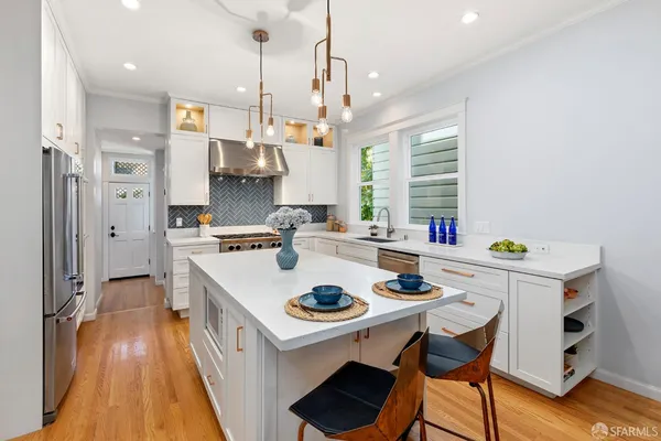 a kitchen that has a stove a table and chairs in it