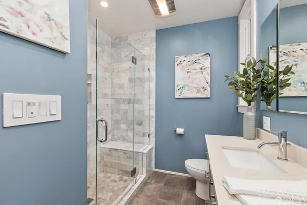 a en suite bathroom with a granite countertop sink and a mirror