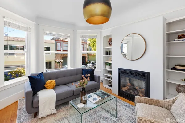 a living room with furniture a fireplace and a large window