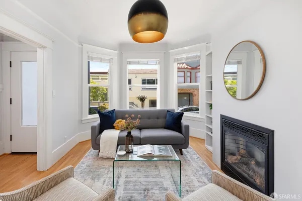 a living room with furniture a rug a lamp and a large window