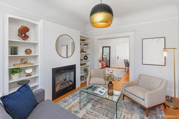 a living room with furniture a fireplace and a large mirror