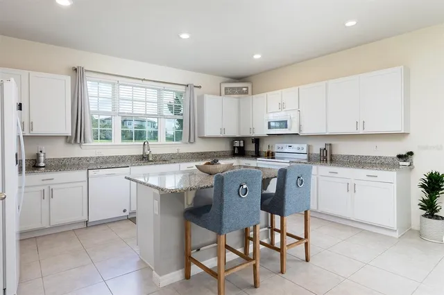 a kitchen with stainless steel appliances granite countertop a stove a sink a refrigerator and a granite counter tops